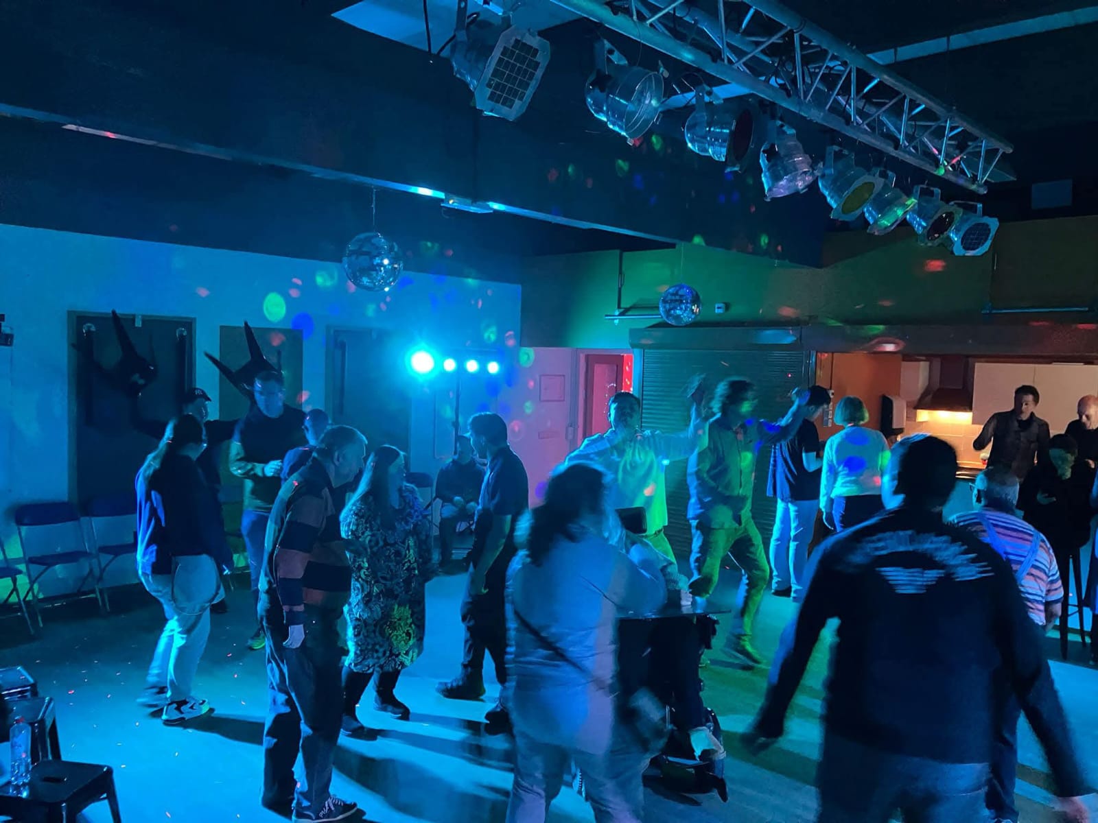 Volle dansvloer met groene laser en discobollen
